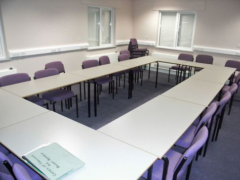 Room with tables set out for meeting Room with tables set out for meeting